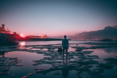 男人站在退潮的海滩上
